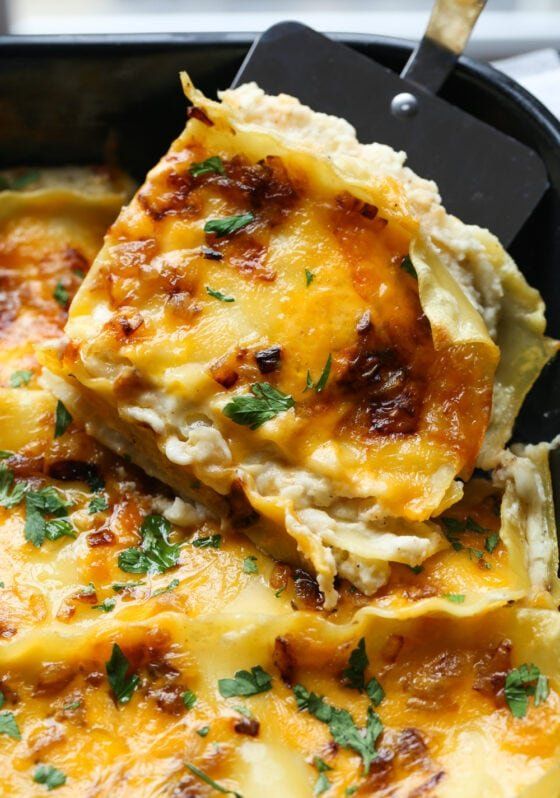 a casserole dish with cheese and parsley