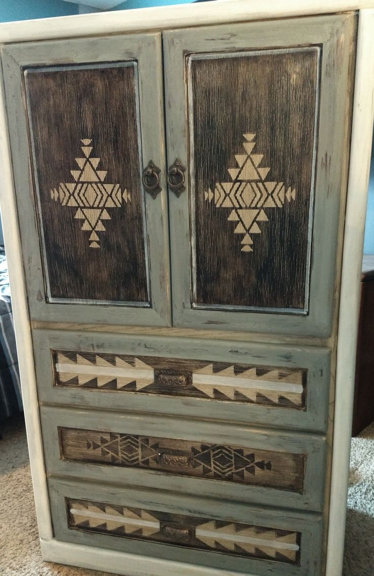 an old wooden cabinet with arrows painted on the front and sides, sitting on a carpeted floor