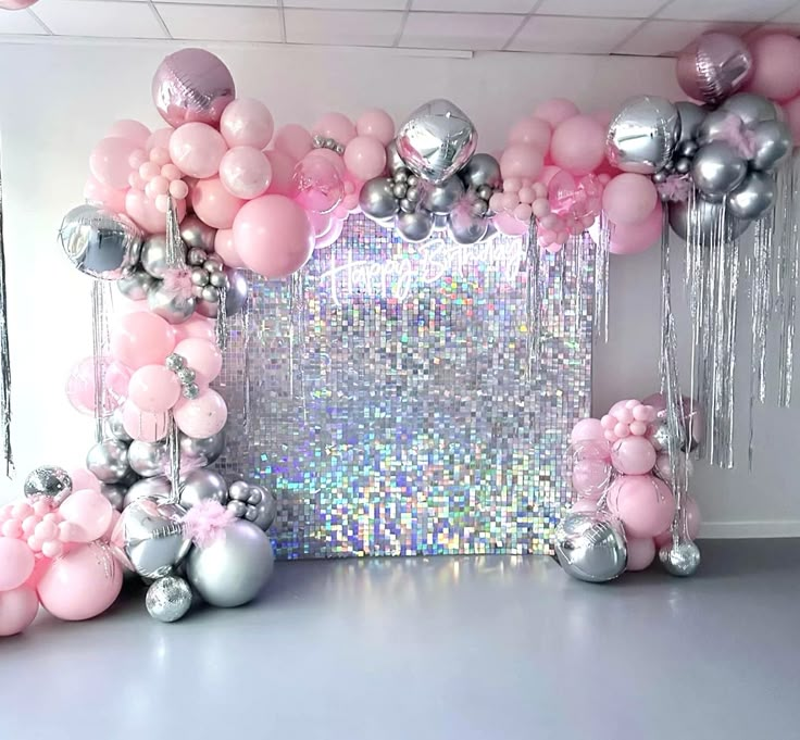 a room filled with balloons and pink and silver decorations