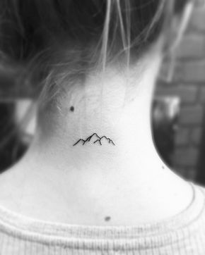 a woman's neck with a small bird tattoo on her left side ribcage