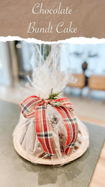 a chocolate bundt cake wrapped in cellophane and tied with a red ribbon