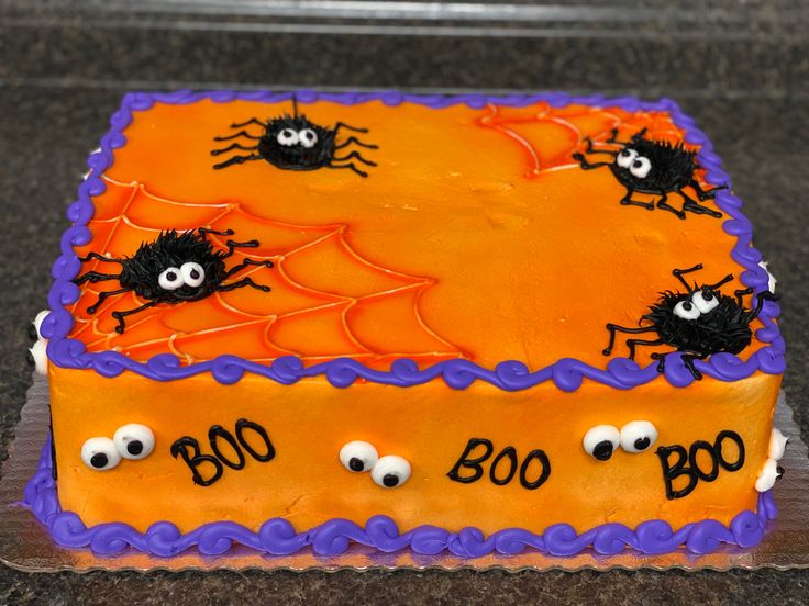 a cake decorated with orange and purple icing has googly eyes on the top