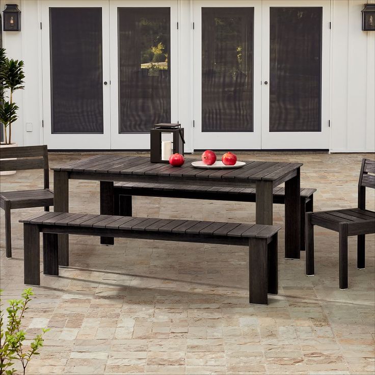 a wooden table and chairs sitting on a patio