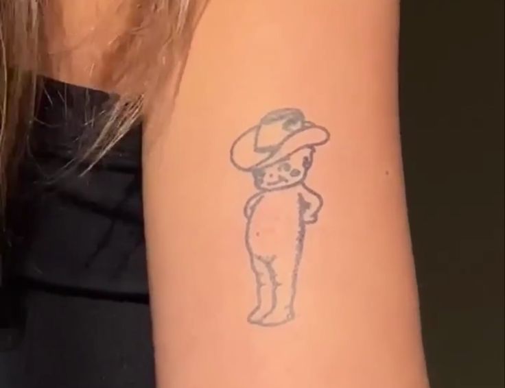 a person with a tattoo on their arm that has a cat in a hat on it