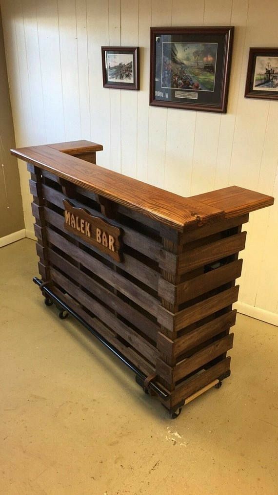 a wooden bar sitting in the middle of a room with pictures on the wall behind it