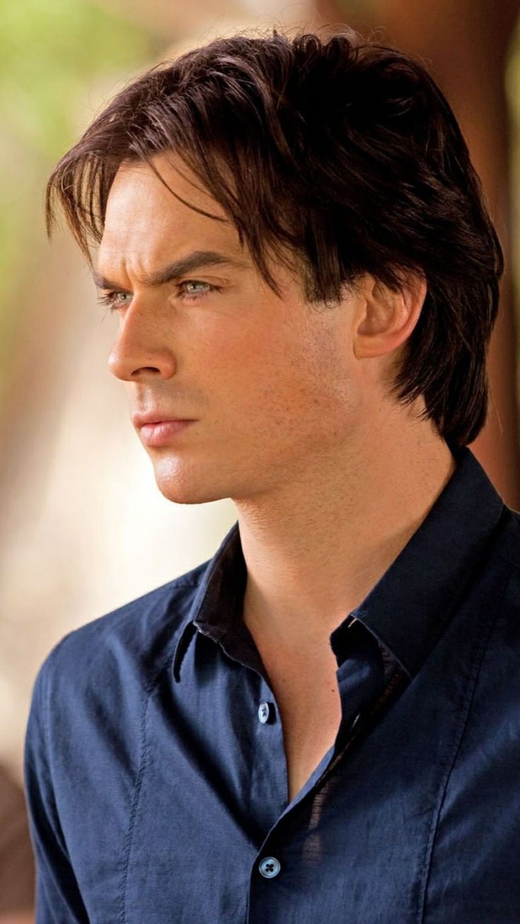 a close up of a person wearing a blue shirt and looking off to the side