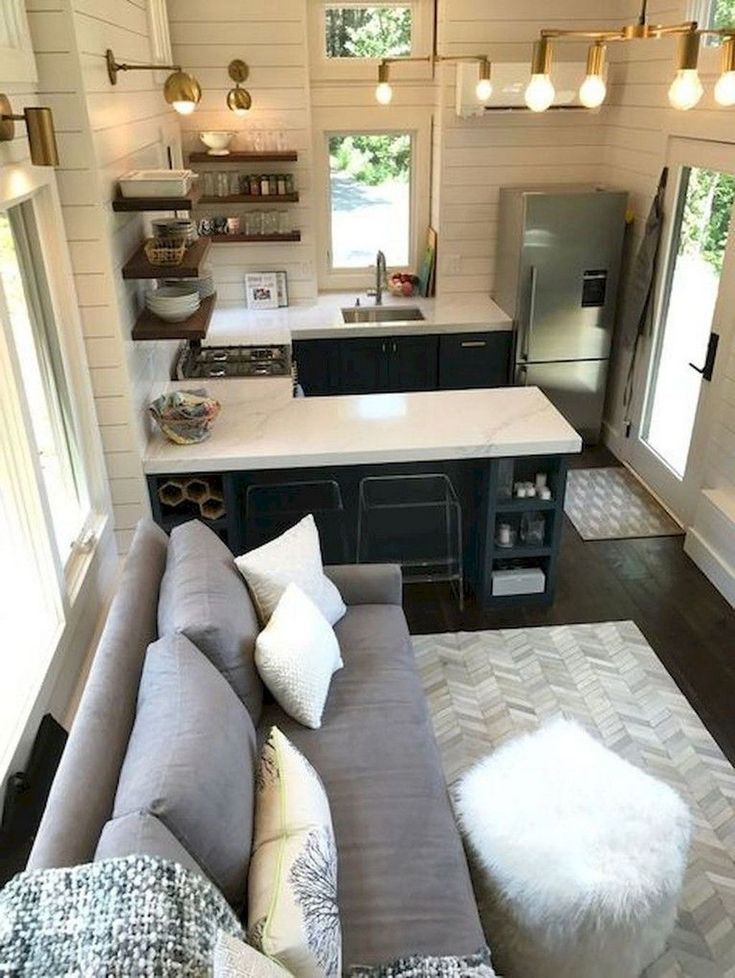 a living room filled with furniture next to a kitchen