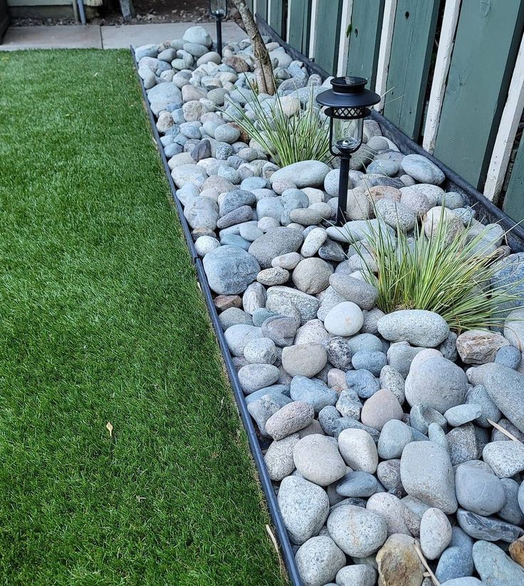 a garden bed with rocks and grass in it