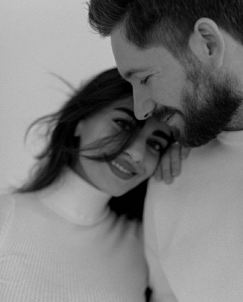 a man and woman are cuddling close to each other in black and white photo