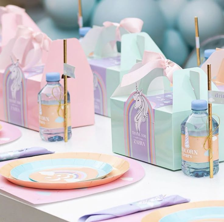 pastel colored table setting with paper plates and napkins, candy bags and water bottles