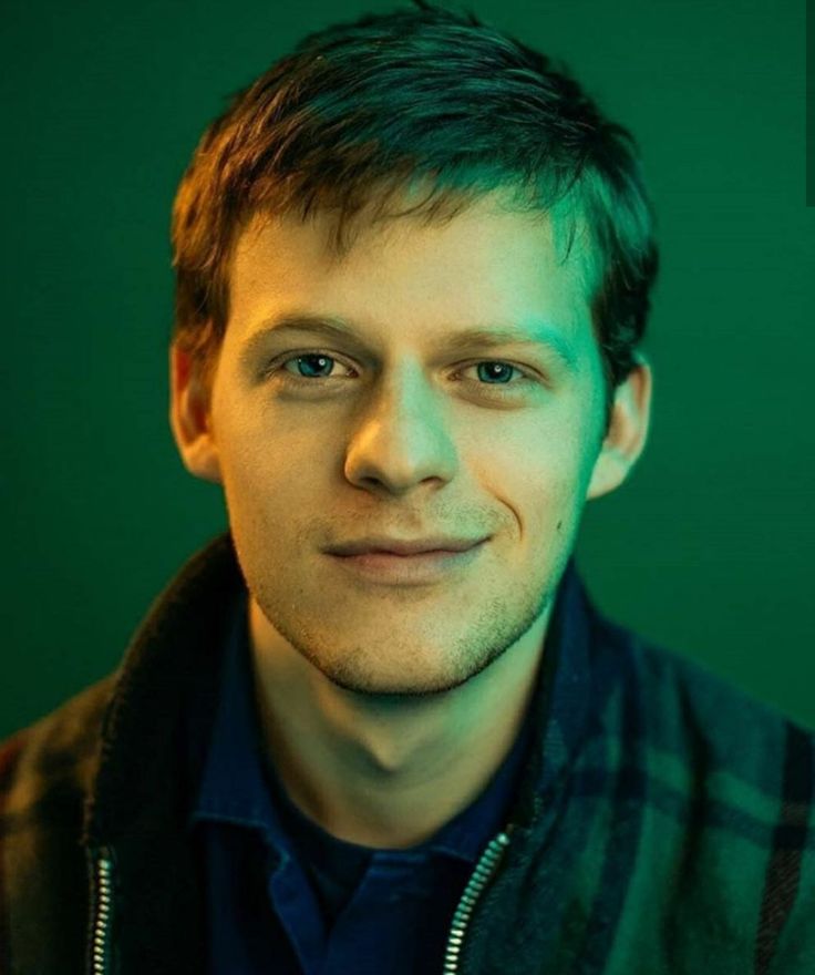 a close up of a person wearing a jacket and looking at the camera with a smile on his face