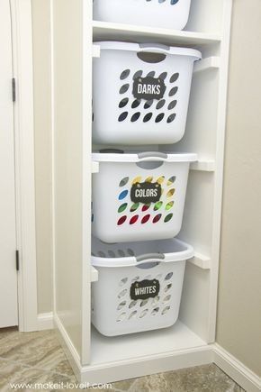 three white baskets are stacked on top of each other in the corner of a closet