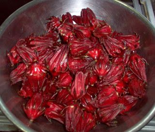 a metal bowl filled with red onions on top of a stove