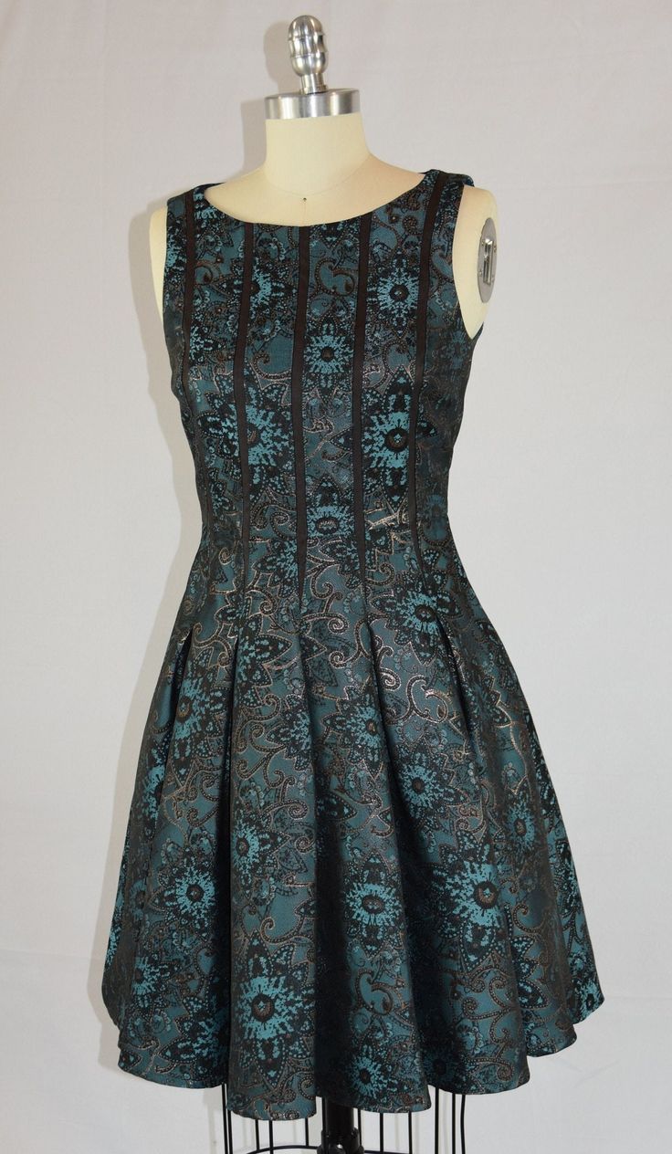 This is a fun, beautiful dancing party dress. The maker is Ivy and Blue, and was made in China. It is a size 2. The fabric is unknown but is soft with turquoise and copper brown metallic threads. The dress is lined, and the skirt has hidden seam pockets! The beaded scarf is included but was not original to the dress. Green Brocade Party Dresses, Elegant Turquoise Festive Dress, Elegant Turquoise Dress For Festive Occasions, Festive Turquoise Dress For Party, Festive Turquoise Party Dress, Fitted Brown Dress For Festive Occasions, Fitted Turquoise Dress For Festive Occasions, Dancing Party, Beaded Scarf