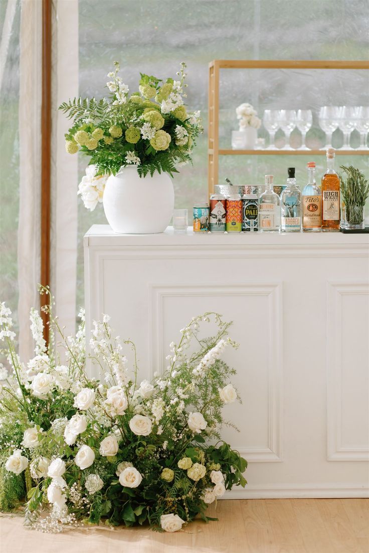 white flowers and greenery in front of a bar