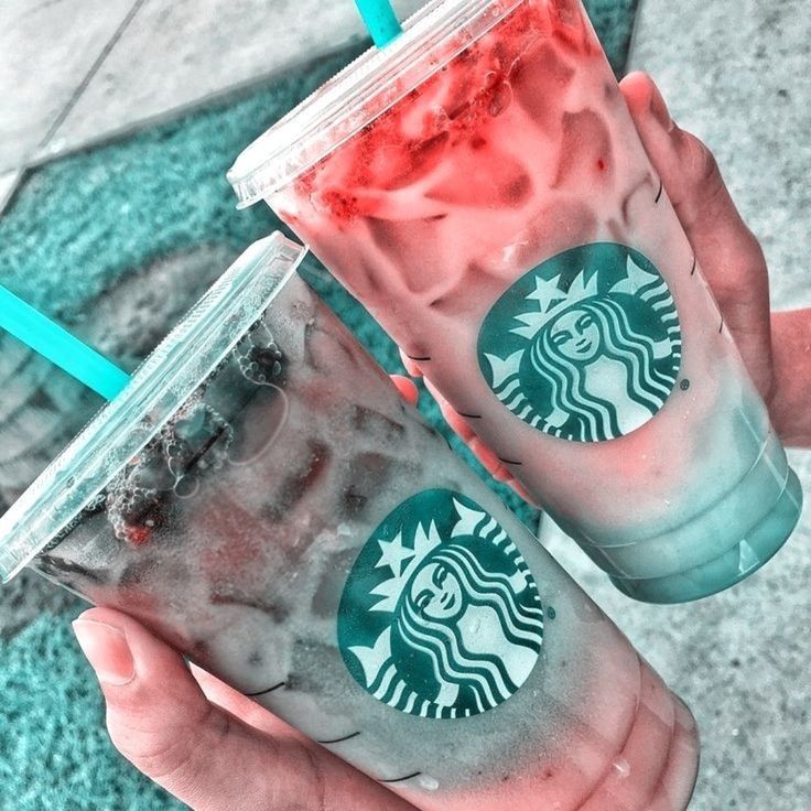 two starbucks drinks in plastic cups with straws on the top and one is red