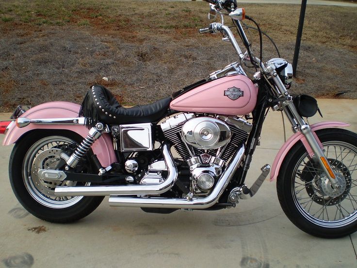 a pink motorcycle is parked on the sidewalk