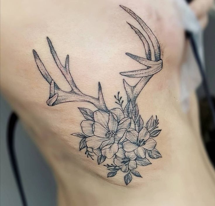 a woman's back with flowers and antlers on it