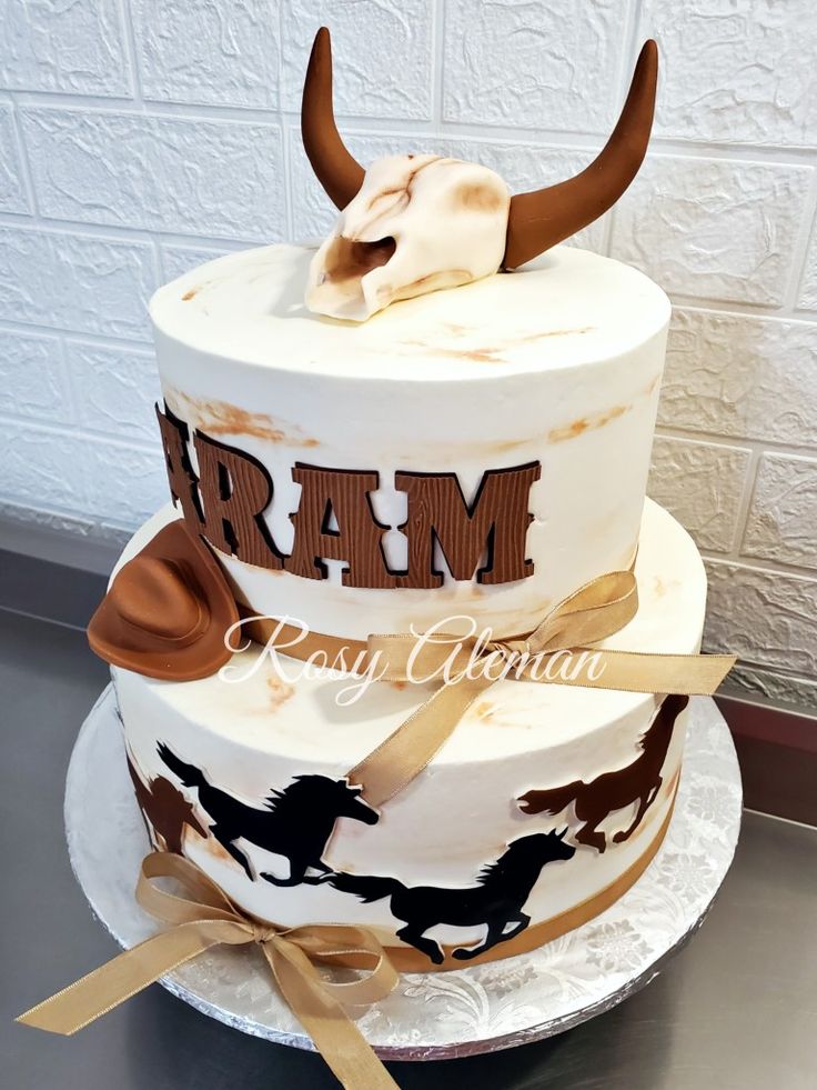 a three tiered cake decorated with long horns and the word ram on it's side