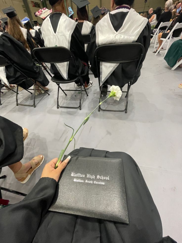 a person sitting in a chair holding a flower