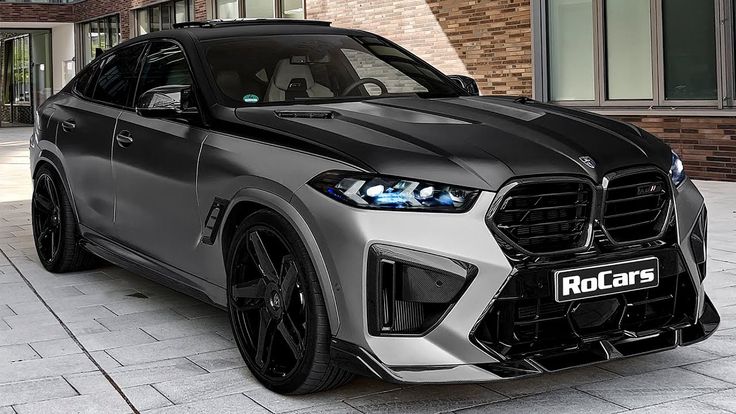 the front end of a silver and black sports utility vehicle parked in front of a brick building