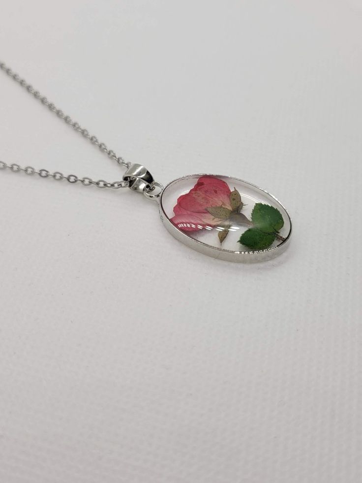 The charm for the necklace is made from epoxy resin with a real pressed flower inside. The flower is a rose bud from Idaho. It has a metal base around the charm, which matches the chain. It is very lightweight and perfect for any occasion, whether formal or casual. Rose Flower Jewelry With Pressed Flowers, Rose Flower Shaped Jewelry With Pressed Flowers, Green Goddess, Kind Person, Rose Bud, Wing Earrings, Pressed Flower, A Rose, Real Flowers