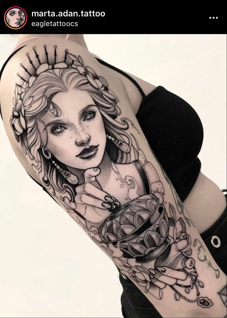 a woman with tattoos on her arm holding a cup