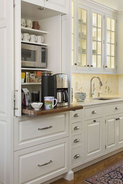 a kitchen with white cabinets and wooden counter tops, including a coffee maker in the corner