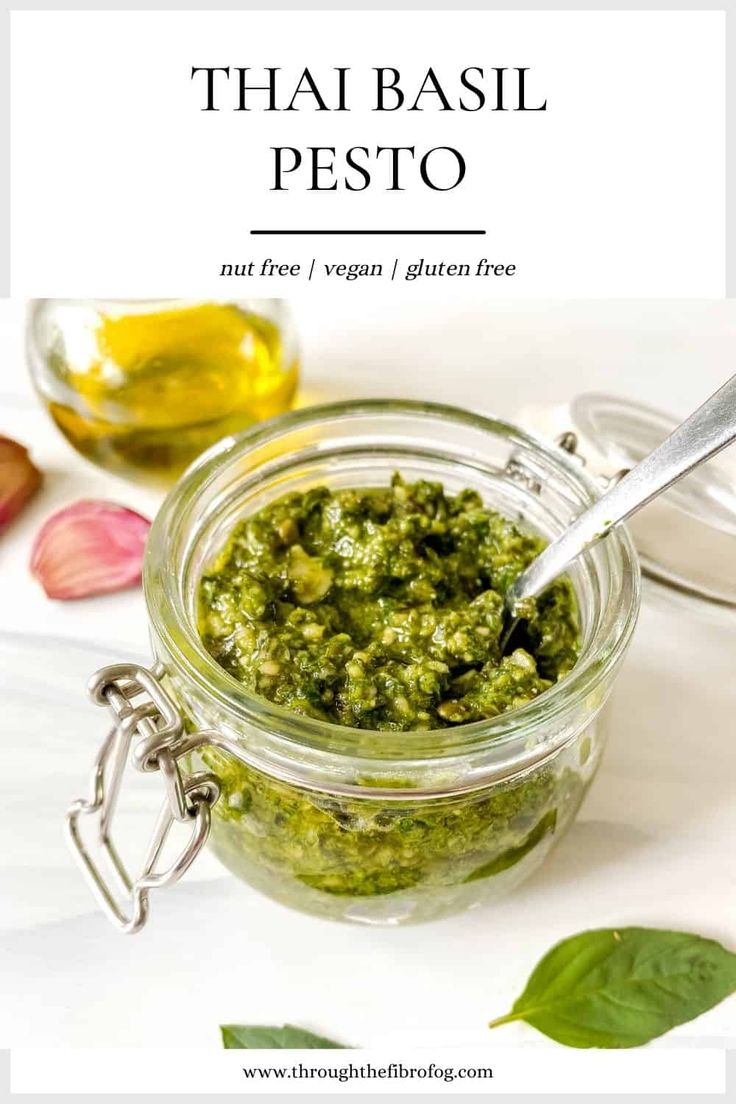 a jar filled with pesto next to a spoon