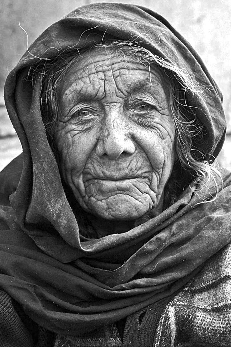 an old woman wearing a headscarf and scarf