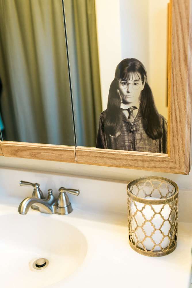 a bathroom sink with a mirror above it and a lit candle in front of it