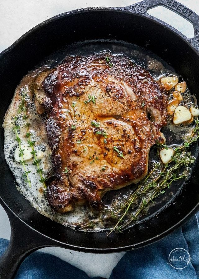 a skillet with some meat and potatoes in it