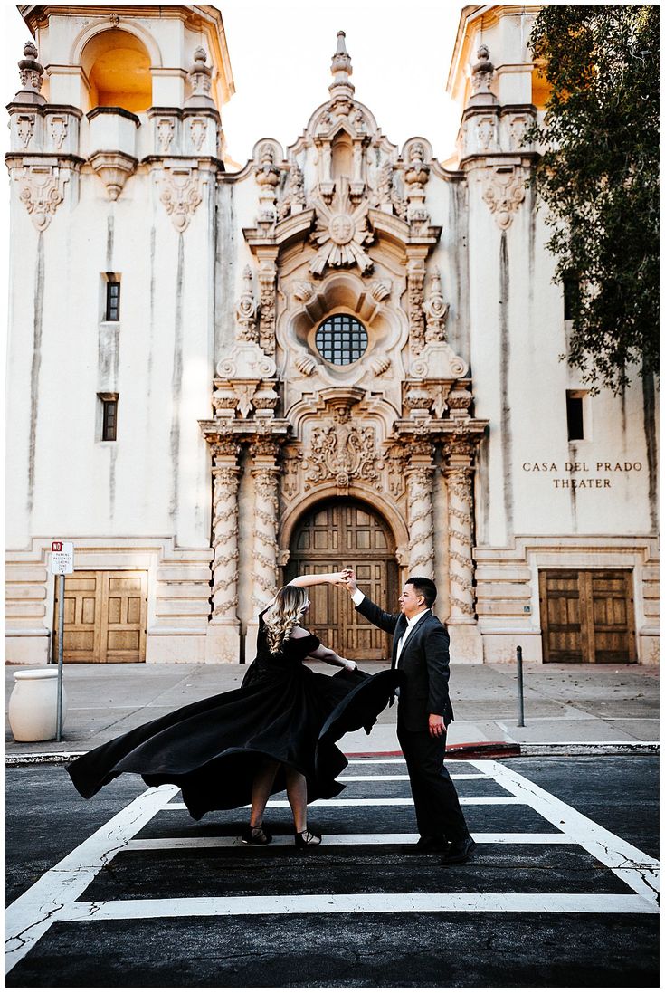 a man and woman dancing in front of an old building