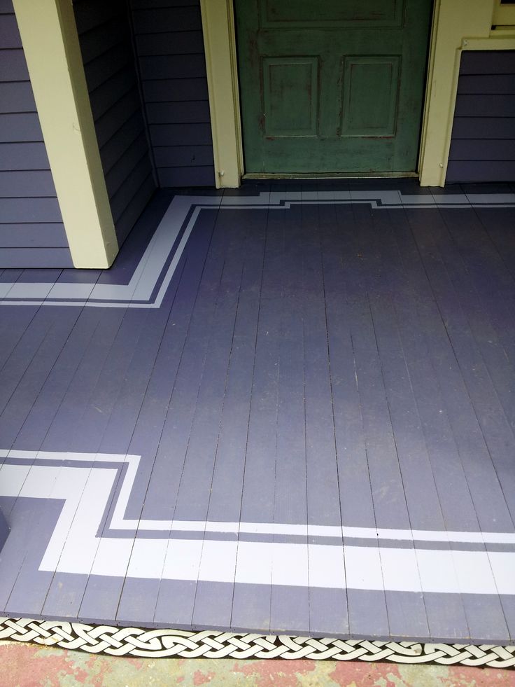 the front porch is painted with blue and white stripes, along with a green door