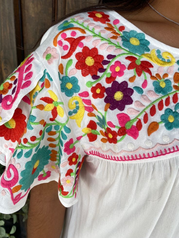 Fiesta Style Top with Signature Multi-Colored Embroidery and Butterfly Sleeves Bring the vibrant spirit of a fiesta to your wardrobe with our Fiesta Style Top. Featuring our signature multi-colored embroidery and elegant butterfly sleeves, this top is perfect for adding a splash of color and a touch of sophistication to any outfit. Designed for both comfort and style, it's a must-have for any fashion-forward wardrobe. Key Features: Fiesta-Inspired Design: Celebrate in style with a top that embodies the festive spirit with its lively colors and design. Signature Multi-Colored Embroidery: Our exclusive multi-colored embroidery adds a unique and eye-catching detail to this top. Butterfly Sleeves: The flowing butterfly sleeves offer a graceful and feminine touch, enhancing the overall look. Co Festive White Top With Embroidered Sleeves, Spring Festival Multicolor Blouse, Multicolor Summer Blouse For Festive Occasions, Summer Festive Multicolor Blouse, Spring Multicolor Embroidered Tops With Sleeves, Fitted Multicolor Floral Embroidered Top, Multicolor Short Sleeve Embroidered Top For Festive Occasions, Floral Print Summer Festive Tops, Fitted Multicolor Embroidered Top