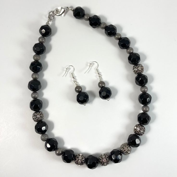 Necklace & Earring Set: Necklace - 18 inches. 14 mm black glass faceted beads with contrasting silver decorative beads. Silver lobster clasp. Earrings - Black glass faceted bead and silver contrast bead, silver fish hooks. Black Jewelry With Faceted Beads For Gift, Black Faceted Beads For Gifts, Silver Faceted Onyx Jewelry, Faceted Silver Beaded Necklace For Party, Silver Faceted Beaded Jewelry, Silver Jewelry With Faceted Round Beads, Black Faceted Jewelry For Party, Silver Beaded Necklace With Faceted Czech Glass Beads, Adjustable Black Czech Glass Jewelry