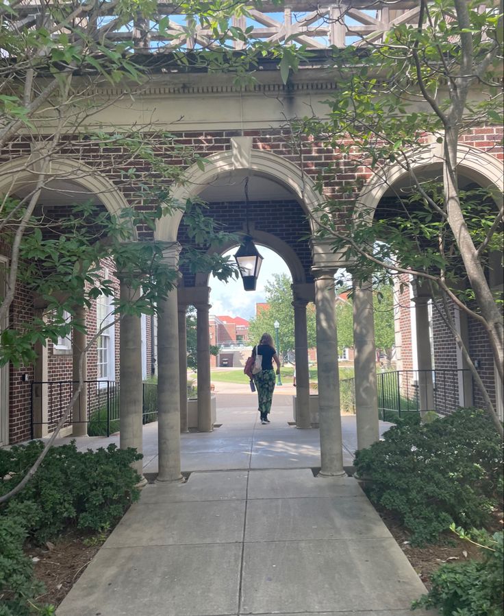 two people are walking under an archway