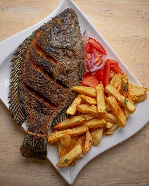 a fish and french fries on a white plate