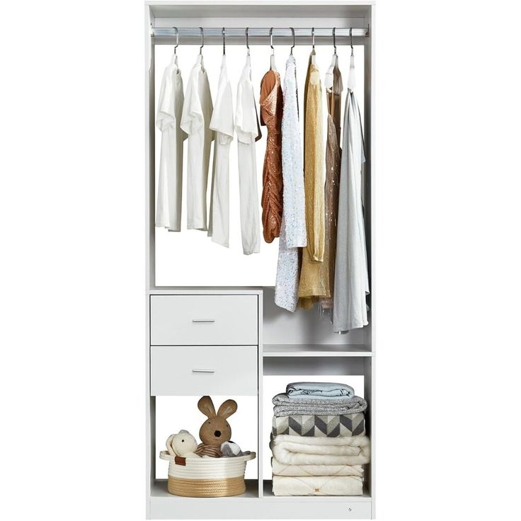 an open white closet with clothes hanging on the rack and a stuffed animal in front