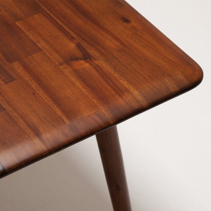 a close up of a wooden table on a white surface with no people around it