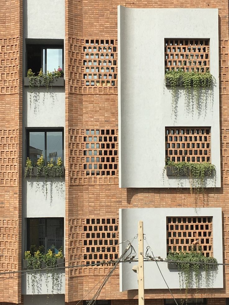 an apartment building with plants growing on the windows