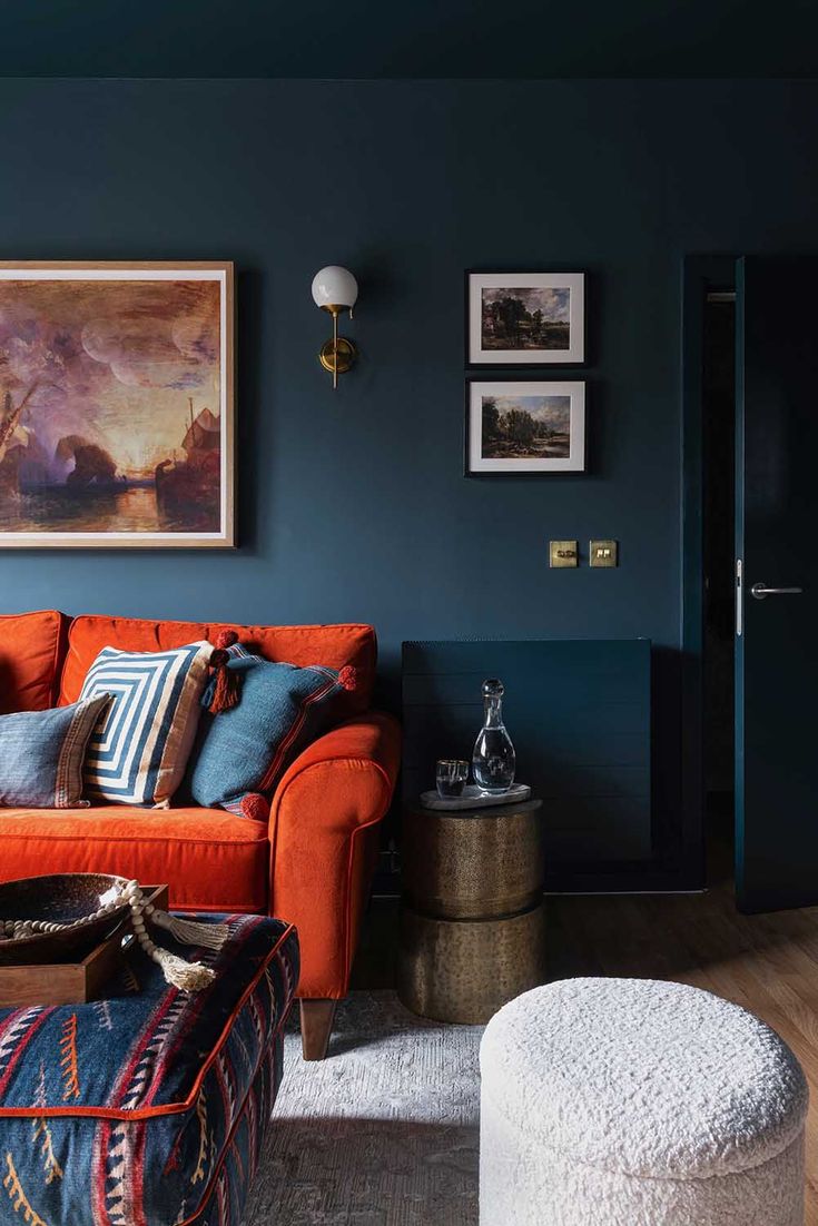 a living room with blue walls and orange couches