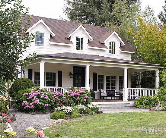 a white house with flowers in the front yard