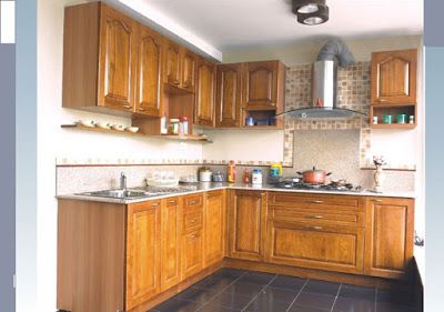 a kitchen with wooden cabinets and tile flooring in the center, along with an overhead fan