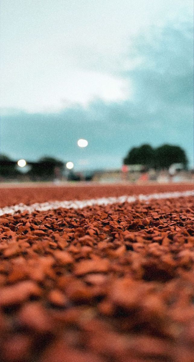 a tennis ball is sitting on the ground in front of an empty court at night