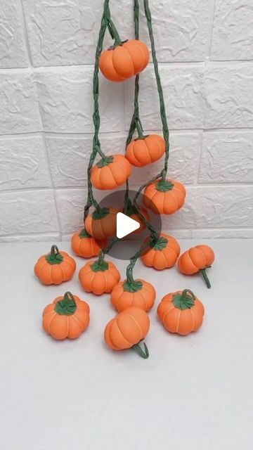 a bunch of fake pumpkins hanging from a string