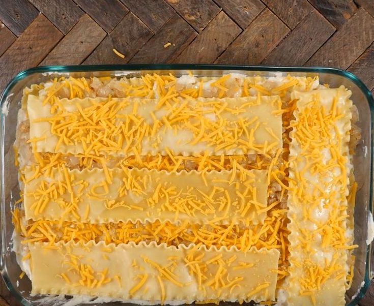 an uncooked casserole with cheese on top