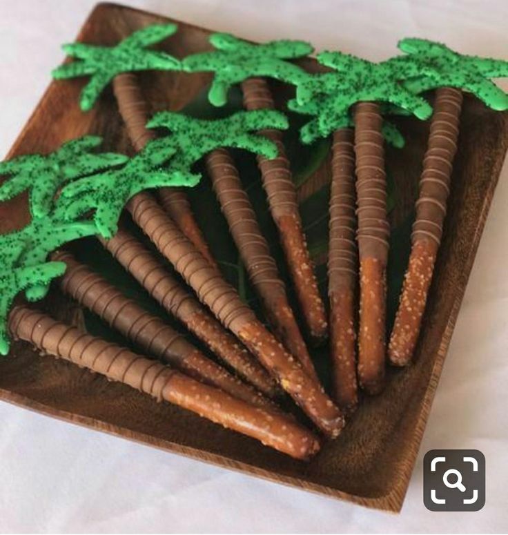 some cookies are arranged in the shape of trees on a wooden platter with green icing