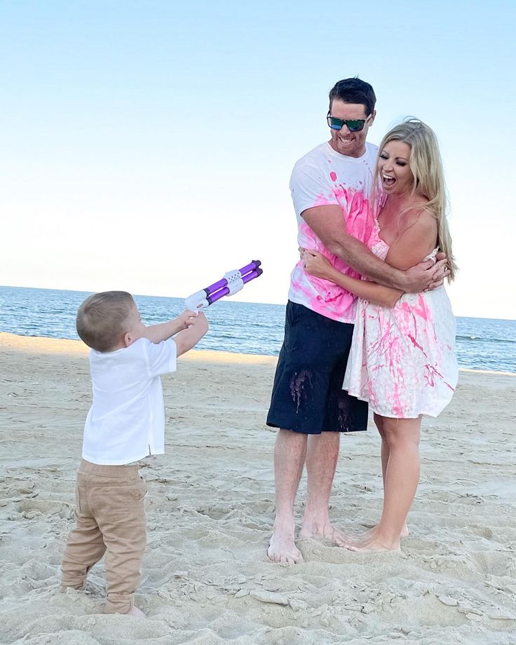 a man, woman and child standing on the beach