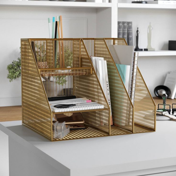 a desk with some books and other items on top of it, next to a book shelf